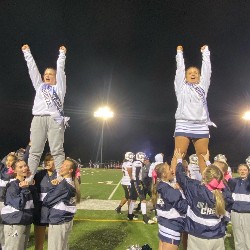 The AAHS Cheer team performs at a football game.